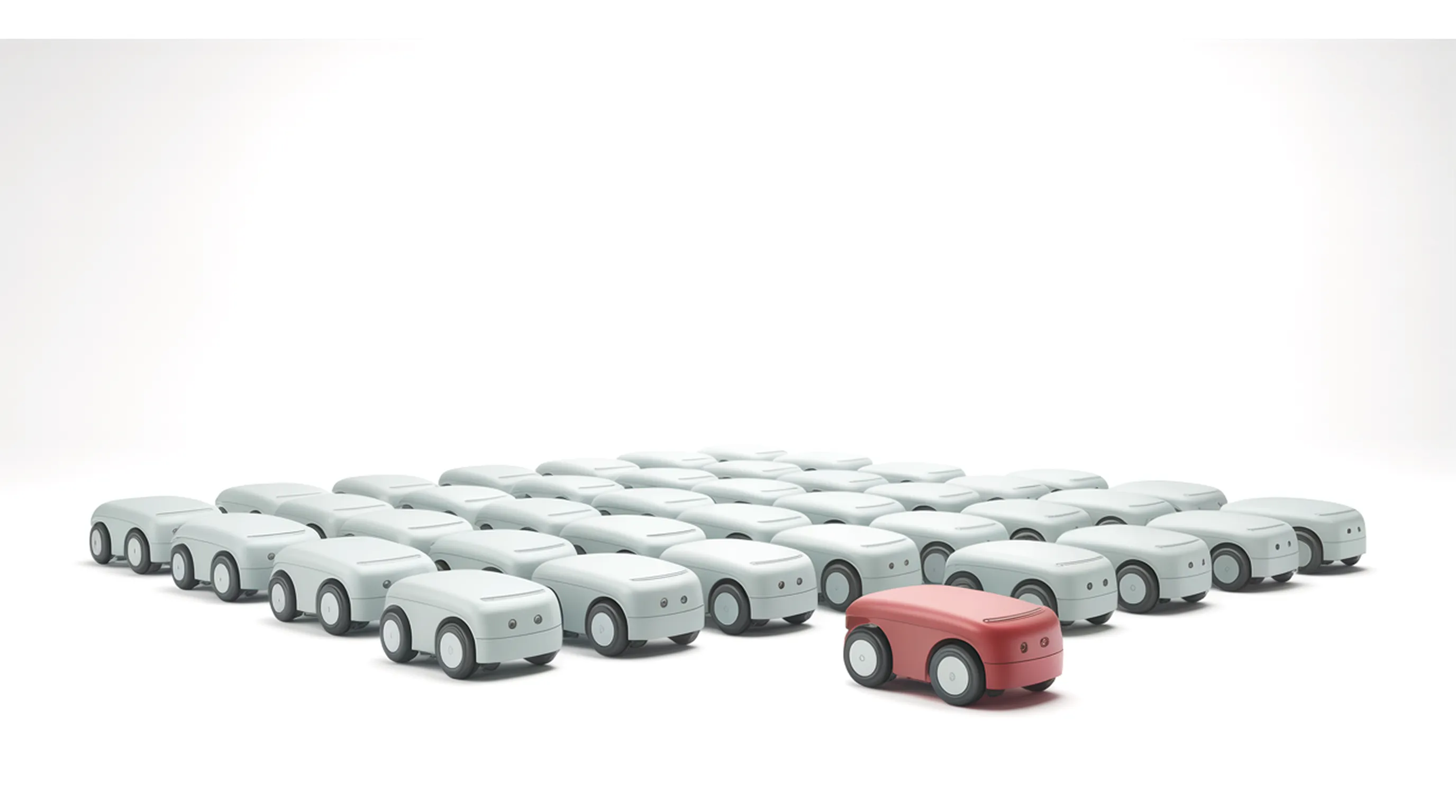 A dense grid of identical small white machined wheeled robot units, with one unit near the centre anodised red.
