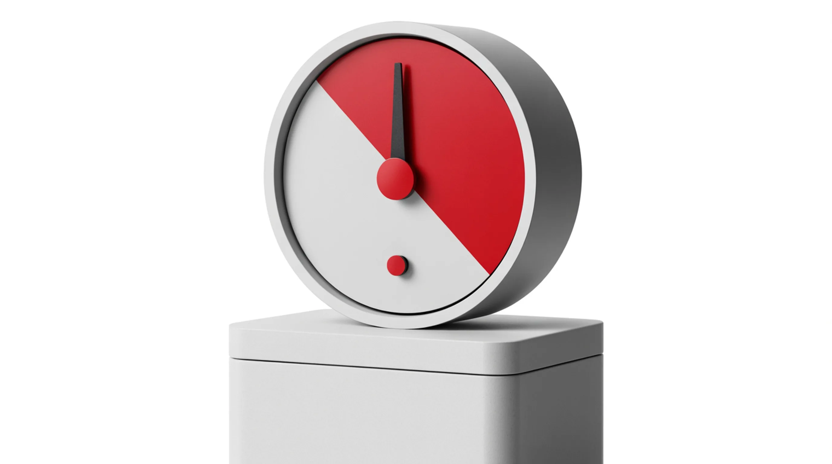 A machined dial gauge on a white plinth, its face split white and red with a steel needle pointing into the red zone.