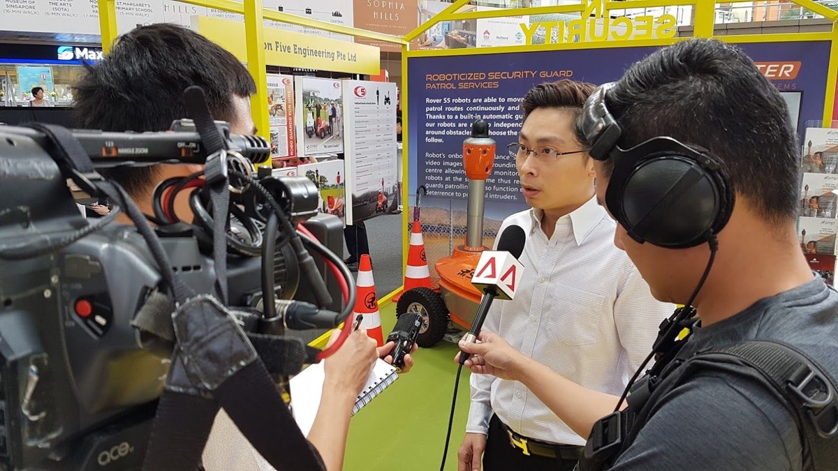 A member of the Orion Five team being interviewed by a broadcast crew at the roadshow stand.