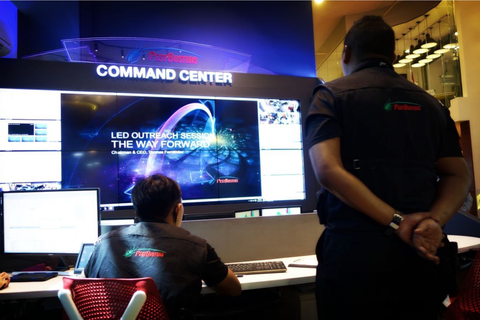 The PestBusters command centre, an operator at the console in front of a video wall carrying camera feeds and monitoring views.