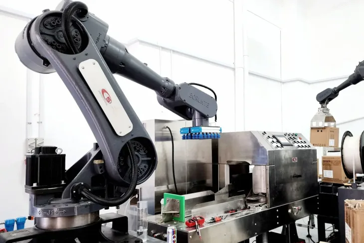Two six-axis industrial robot arms installed over the automated carton cutting machine on the Raymang Eggs line.